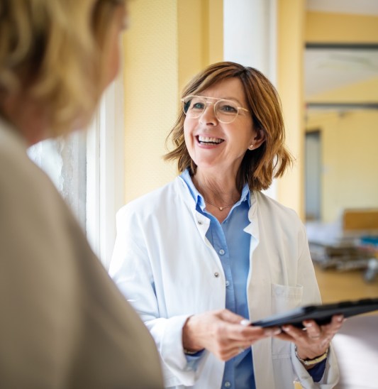 Doctor discussing with woman at nursing home